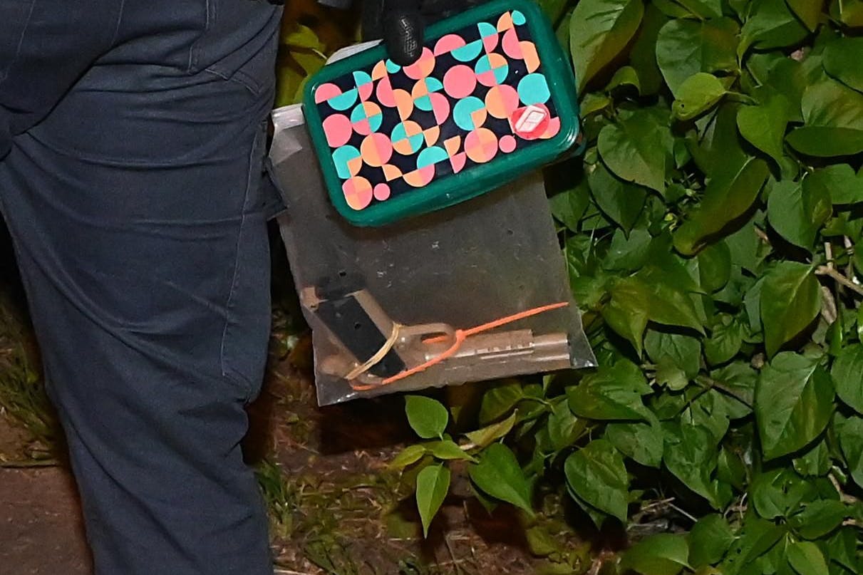 Ein Polizeibeamter stellt die mutmaßliche Tatwaffe sicher. 