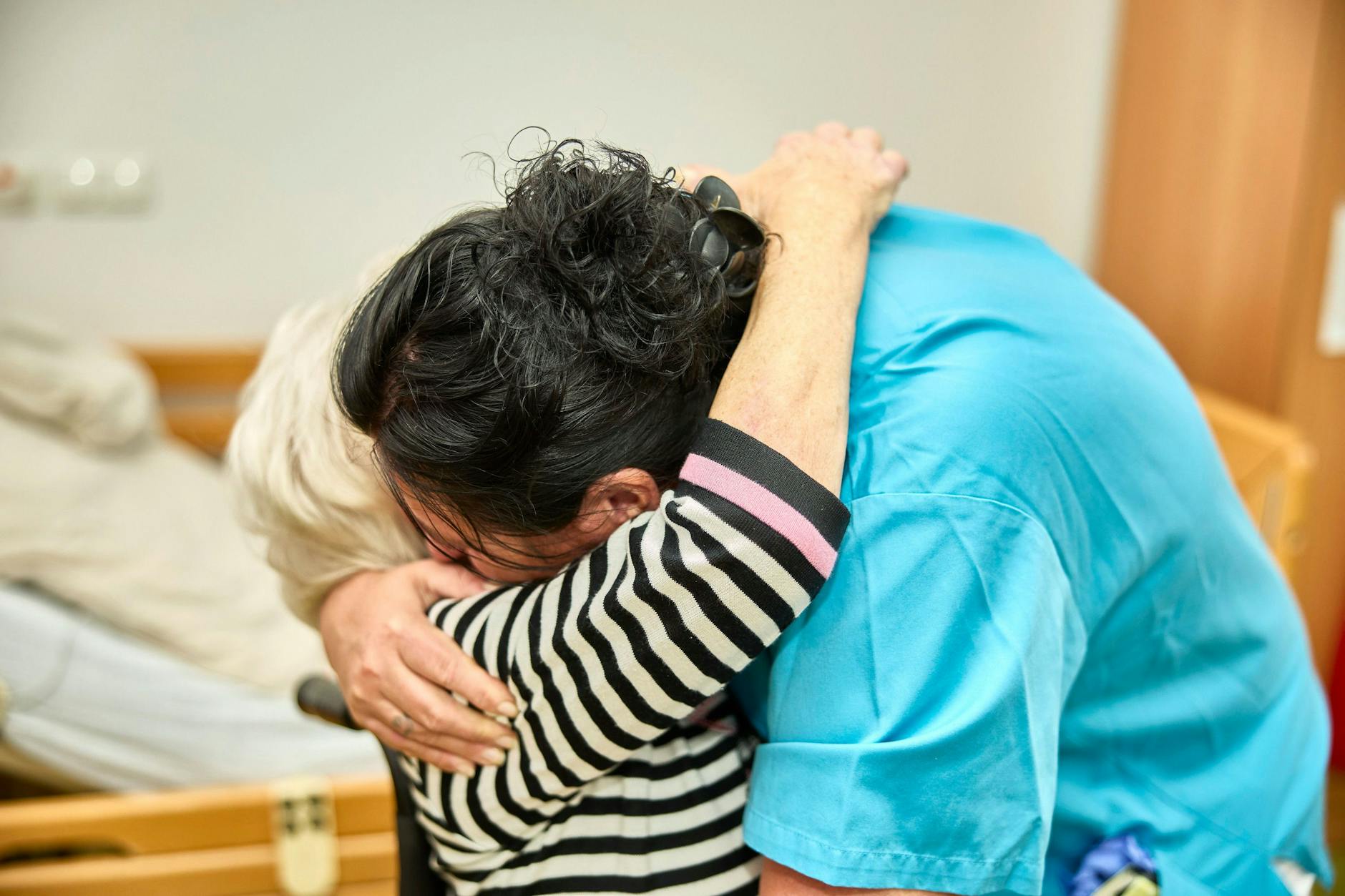 Eine Pflegekraft mit einer Bewohnerin eines Pflegeheims