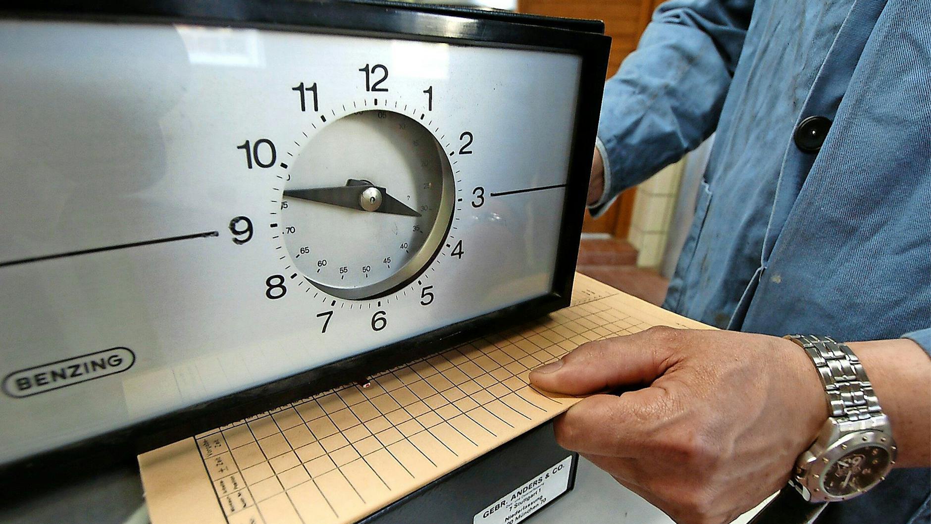 So lief’s früher: Eine Karte zur Arbeitszeiterfassung wird unter eine Stechuhr gelegt.