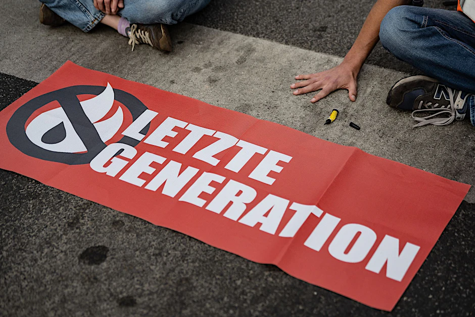 ARCHIV - Ein Aktivist der Gruppe «Letzte Generation» blockiert eine Kreuzung.  