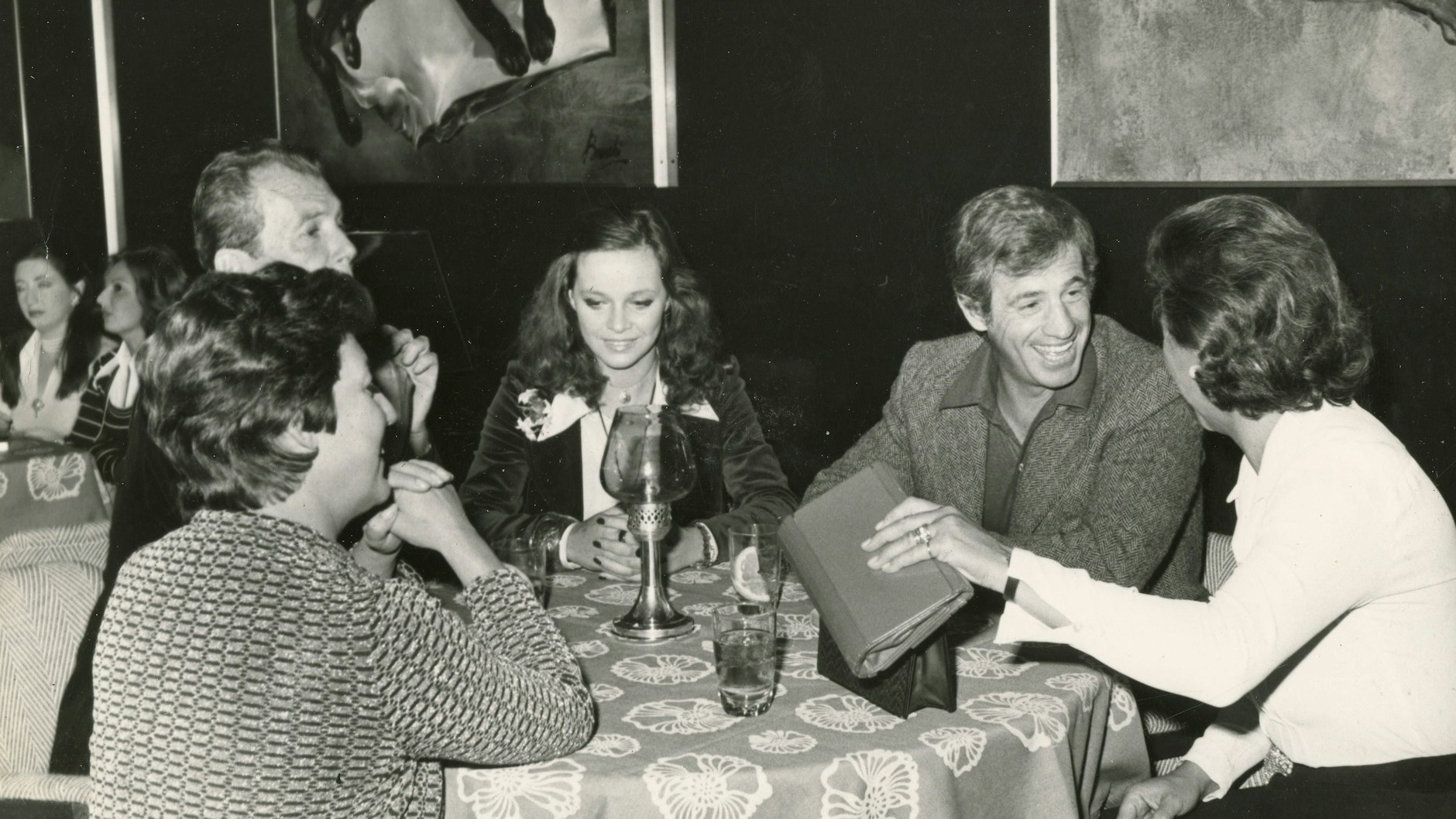 Jean-Paul Belmondo mit der italienischen Schauspielerin Laura Antonelli und Freunden in einem Restaurant (1970). Der französische Filmstar ist der Namenspatron für das Berliner Lokal, das jetzt von Tierschützern angezeigt wurde.&nbsp;