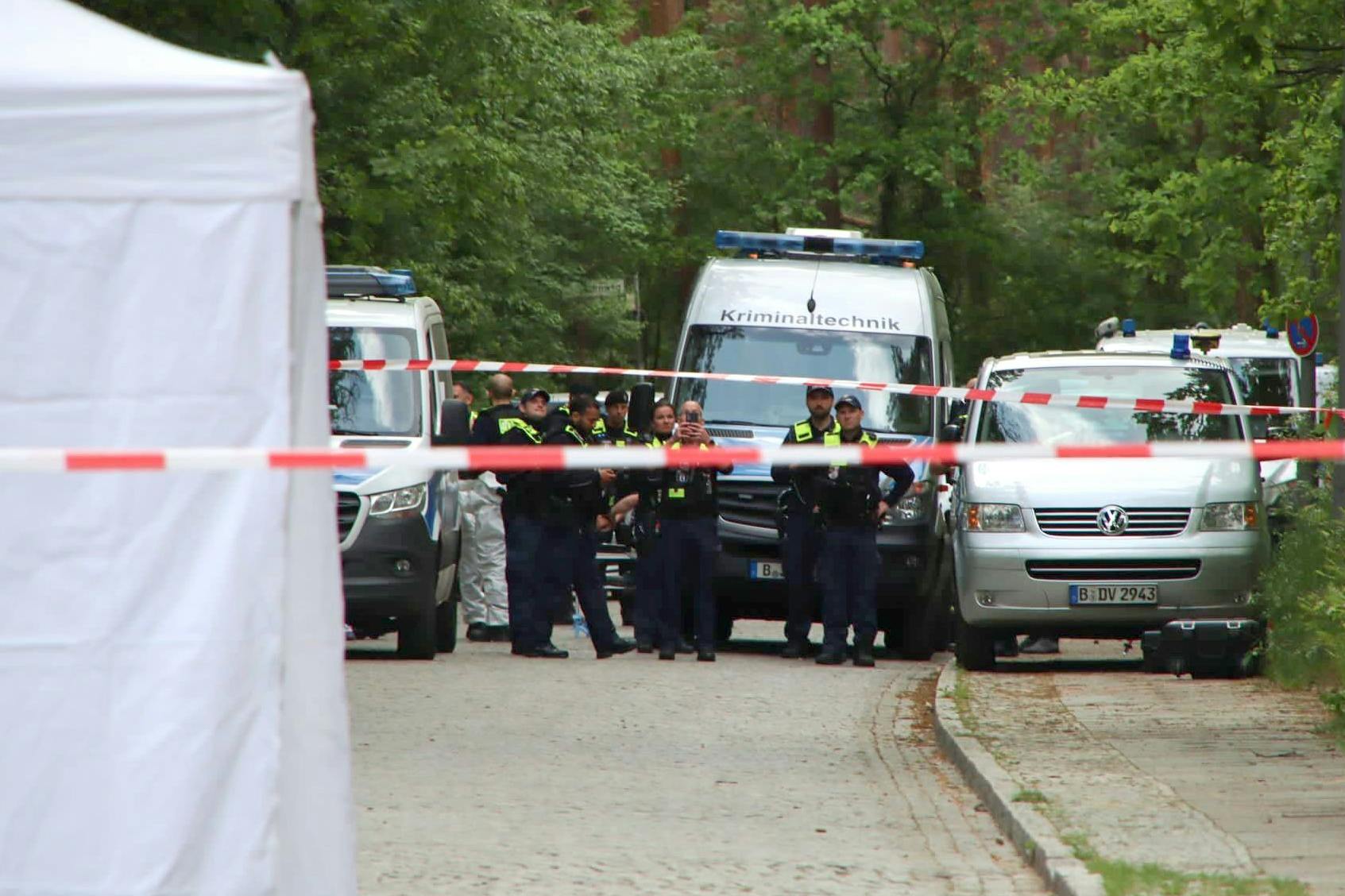 Polizisten sind am Tatort in Berlin-Gatow im Einsatz. In dem Untersuchungszelt (links im Bild) liegt die Leiche eines Mannes, der erschossen worden war.