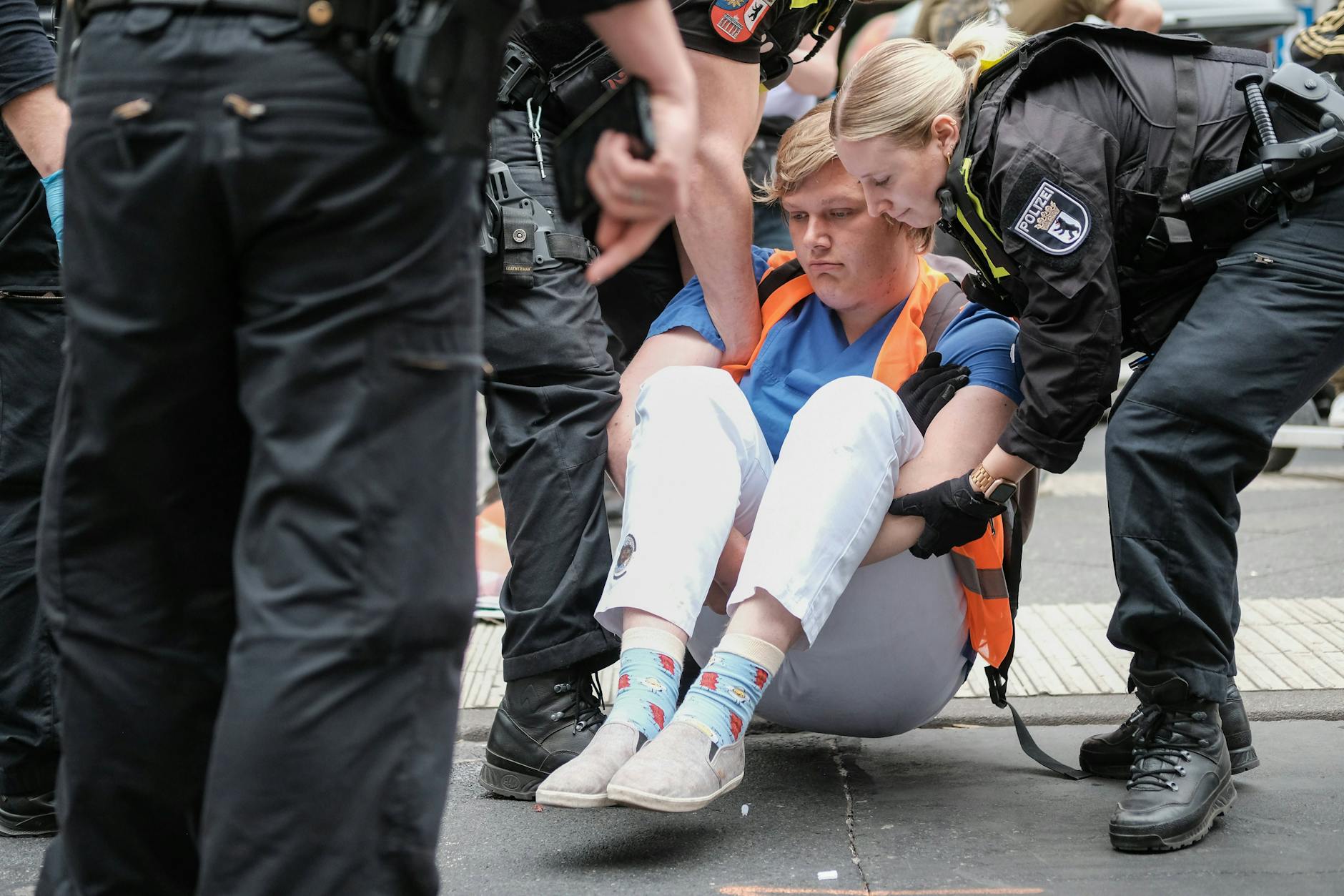Eine Blockade der Letzten Generation in Berlin. Aktivisten müssen weggetragen werden. Wer trägt eigentlich die Kosten?