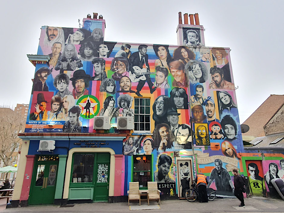 Fassade in Brighton mit Popstars. Auch die „Kissing Coppers“ von Banksy sind mit dabei – rechts unten.