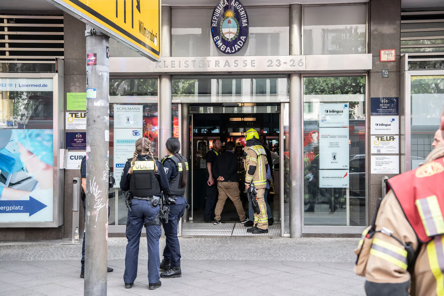 Einsatzkräfte der Feuerwehr und Polizei stehen in einem Hauseingang an der Kleiststraße. In dem mehrgeschossigen Gebäude kam es zu einem tödlichen Unfall mit einem Paternoster. 