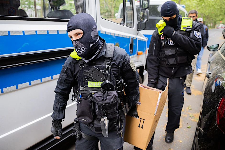 dpatopbilder - Polizisten tragen bei einer Hausdurchsuchung in Berlin-Kreuzberg einen Karton zu einem Fahrzeug.  