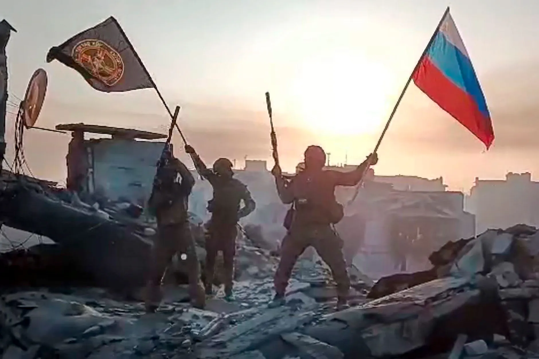 Das Standbild aus einem vom Prigoschin-Pressedienst am 20.05.2023 veröffentlichten Video soll zeigen, wie Angehörige der Wagner-Gruppe eine russische National- und eine Wagner-Flagge auf einem beschädigten Gebäude in der vermutlich komplett zerstörten Stadt Bachmut schwenken. 