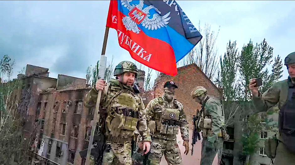 HANDOUT - Denis Puschilin, Chef der teils von Russland besetzten Region Donezk, mit einer Fahne der russisch kontrollierten Region Donezk in Bachmut.  ssian-controlled Donetsk region telegram channel/AP/dpa