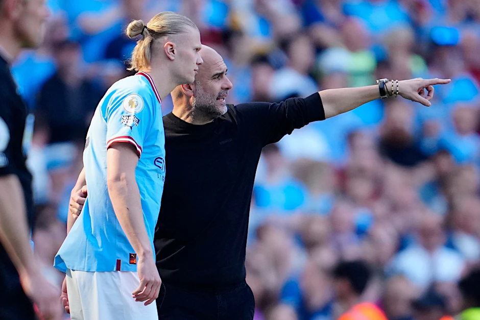 ARCHIV - Pep Guardiola (r), Trainer von Manchester City, spricht mit Torjäger Erling Haaland (l).  