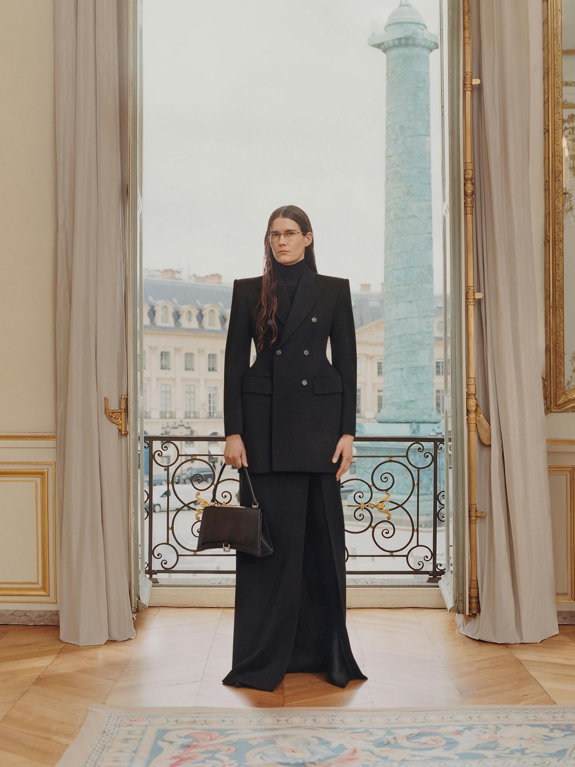 Eliza Douglas in Entwürfen der Balenciaga-Frühjahrskollektion 2024: Hourglass-Blazer aus Wolle, Rollkragenpullover aus Kaschmir-Rippstrick, geschlitzter Maxirock aus Wolle, Leggins-Schuhe aus Elasthan und Ledertasche „Hourglass Hinge Medium“.