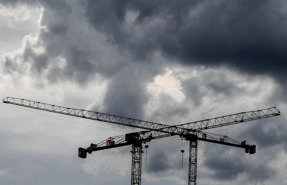ARCHIV - Baukräne sind vor dunklen Wolken zu sehen.  dpa