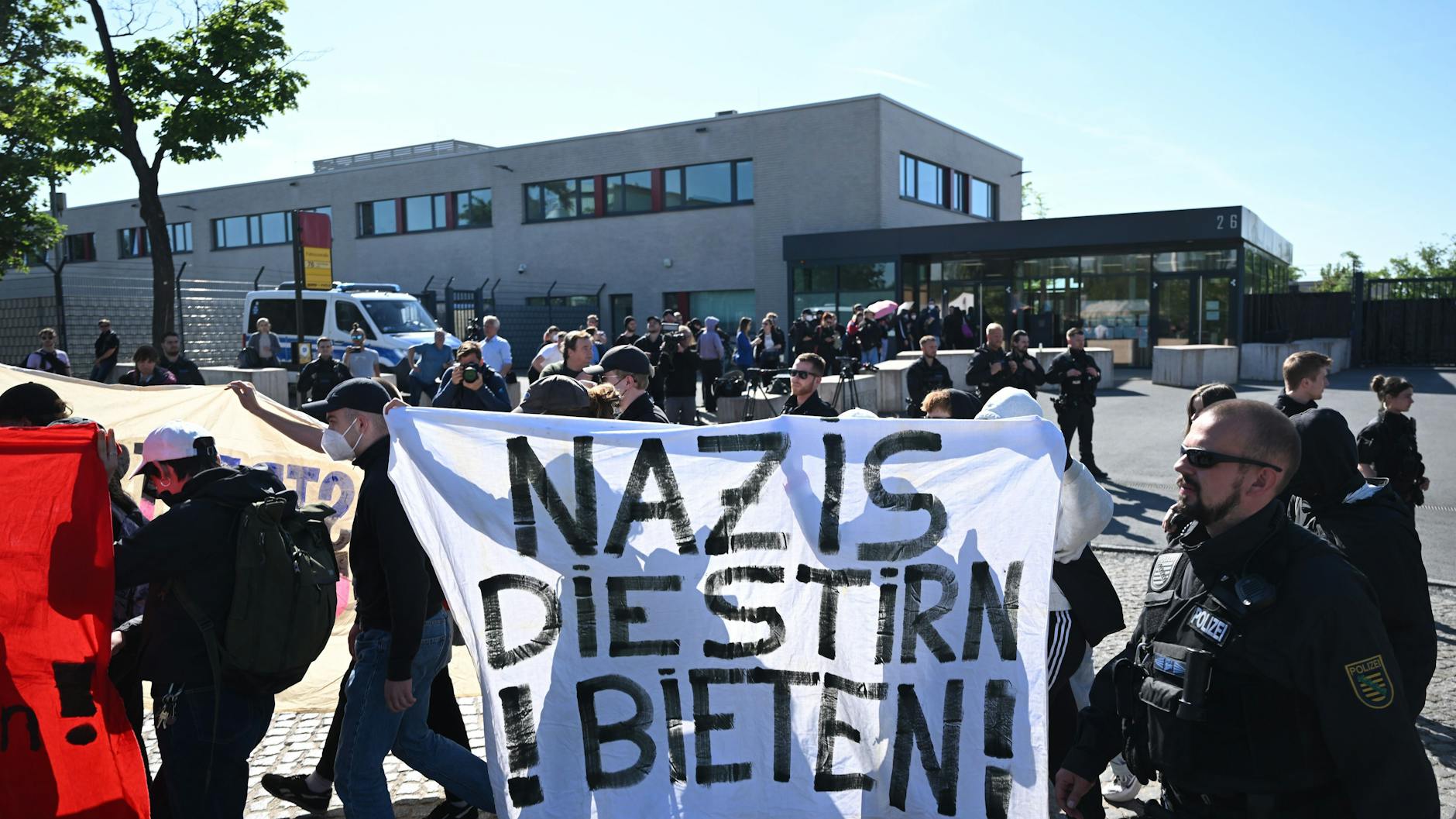 Demonstranten aus dem linken Spektrum laufen vor Beginn der Urteilsverkündung gegen Lina E. und drei Männer vor dem Oberlandesgericht Dresden mit einem Banner entlang.