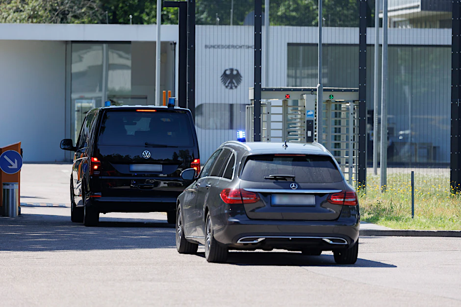 Zivile Fahrzeuge mit Blaulicht fahren nach der Razzia am Mittwoch am Bundesgerichtshof vor.