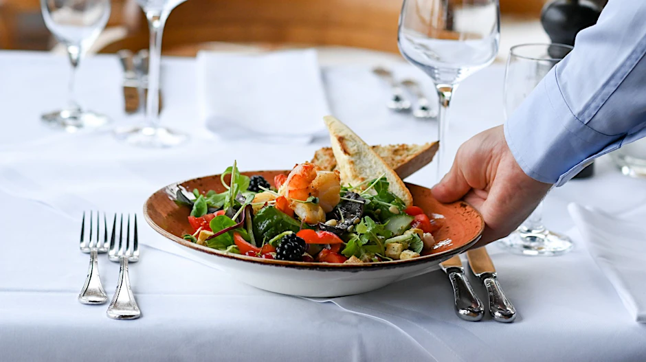 ARCHIV - Ein Kellner serviert einen Salatteller in einem Restaurant.  