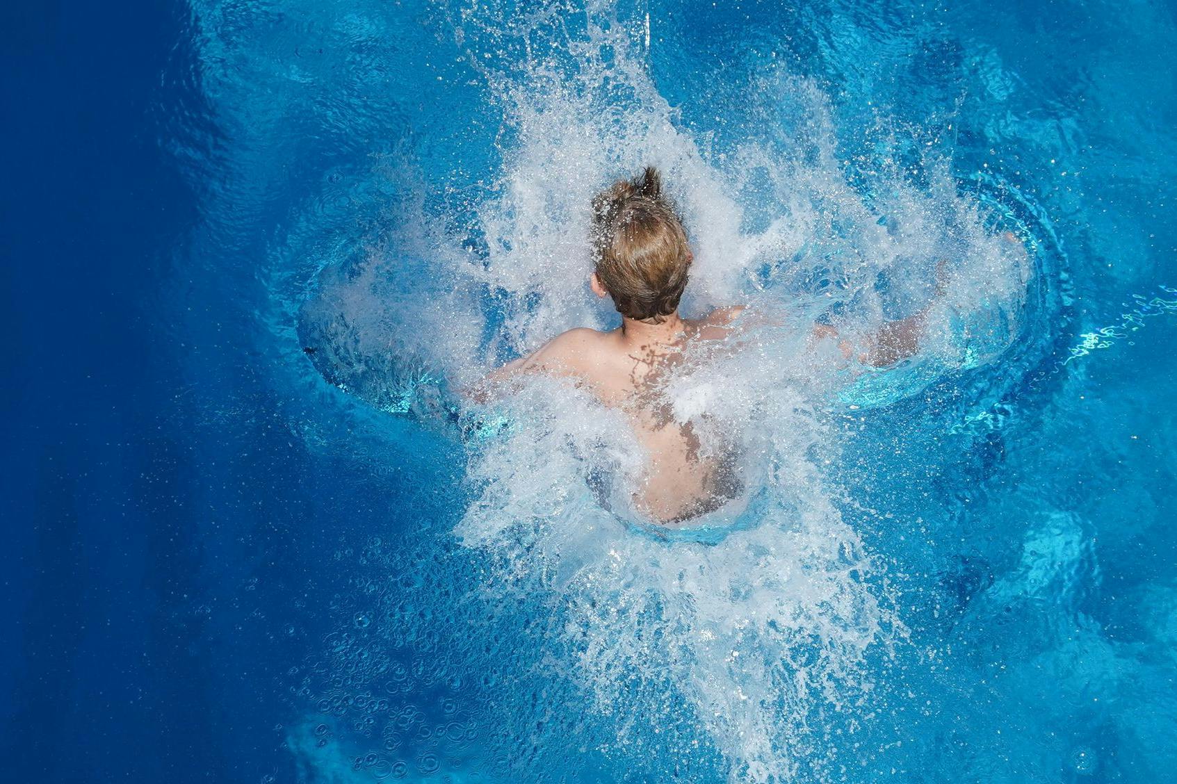 Der Sprung ins kühle Nass eines Freibades