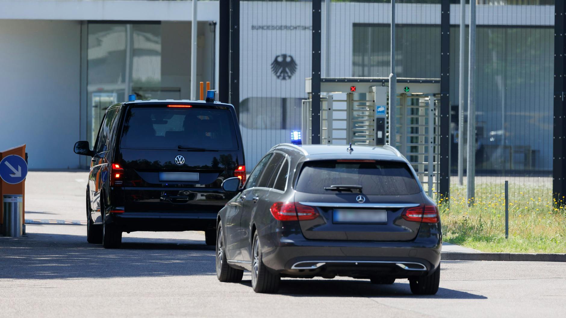 Zivile Fahrzeuge mit Blaulicht fahren am Bundesgerichtshof in Karlsruhe vor: Dort wird über die Haftbefehle gegen mutmaßliche IS-Unterstützer entschieden.
