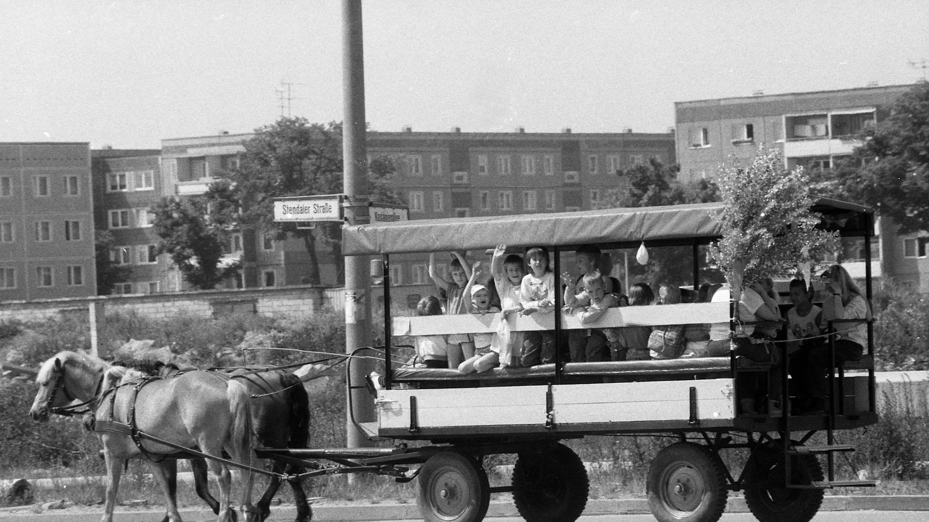 Ein Kremserwagen mit Kindern fährt am Internationalen Kindertag durch die Stendaler Straße im Ost-Berliner Stadtteil Hellersdorf. 