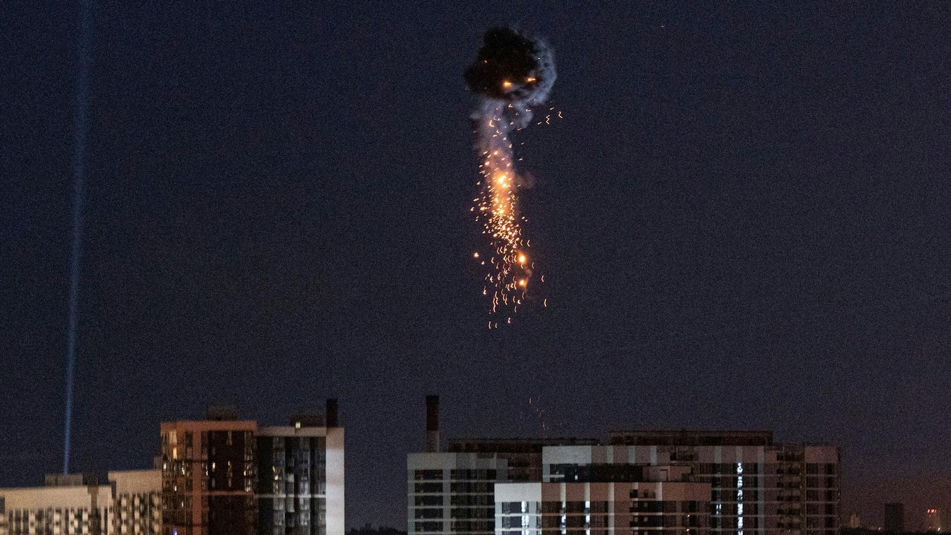 Ein glühender Trümmerregen geht nach dem Abschuss einer russischen Rakete auf Kiew nieder.