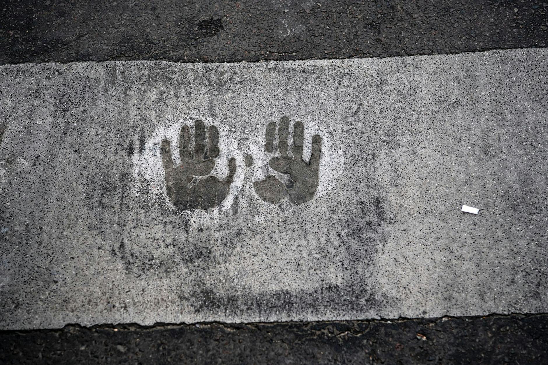 dpatopbilder - Der Abdruck von zwei Händen bei einer Straßenblockade der Letzten Generation auf dem Mühlendamm in Berlin.
