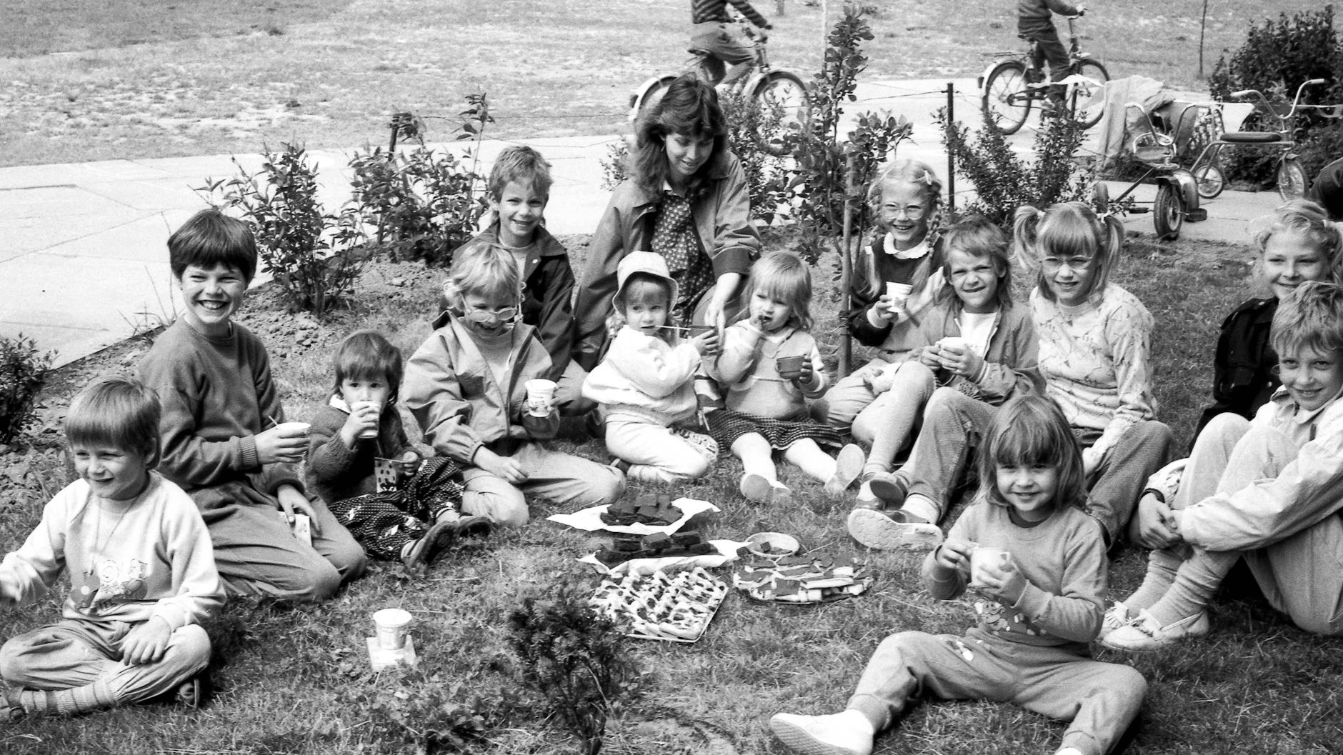 Eine DDR-Hausgemeinschaft feiert 1989 den Internationalen Kindertag mit einem Picknick. In Rostock-Dierkow organisierten damals zwölf Mietparteien in ihrem Wohnaufgang dieses Fest zum Kindertag.