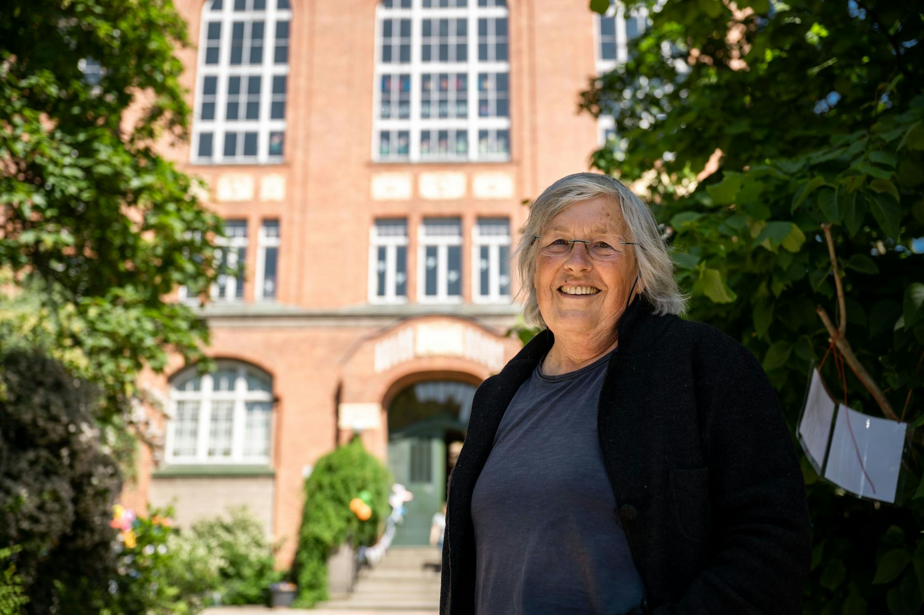 Elizabeth Shaws Tochter Anne Schneider (75) vor der Grundschule in Pankow, die den Namen ihrer Mutter trägt. 