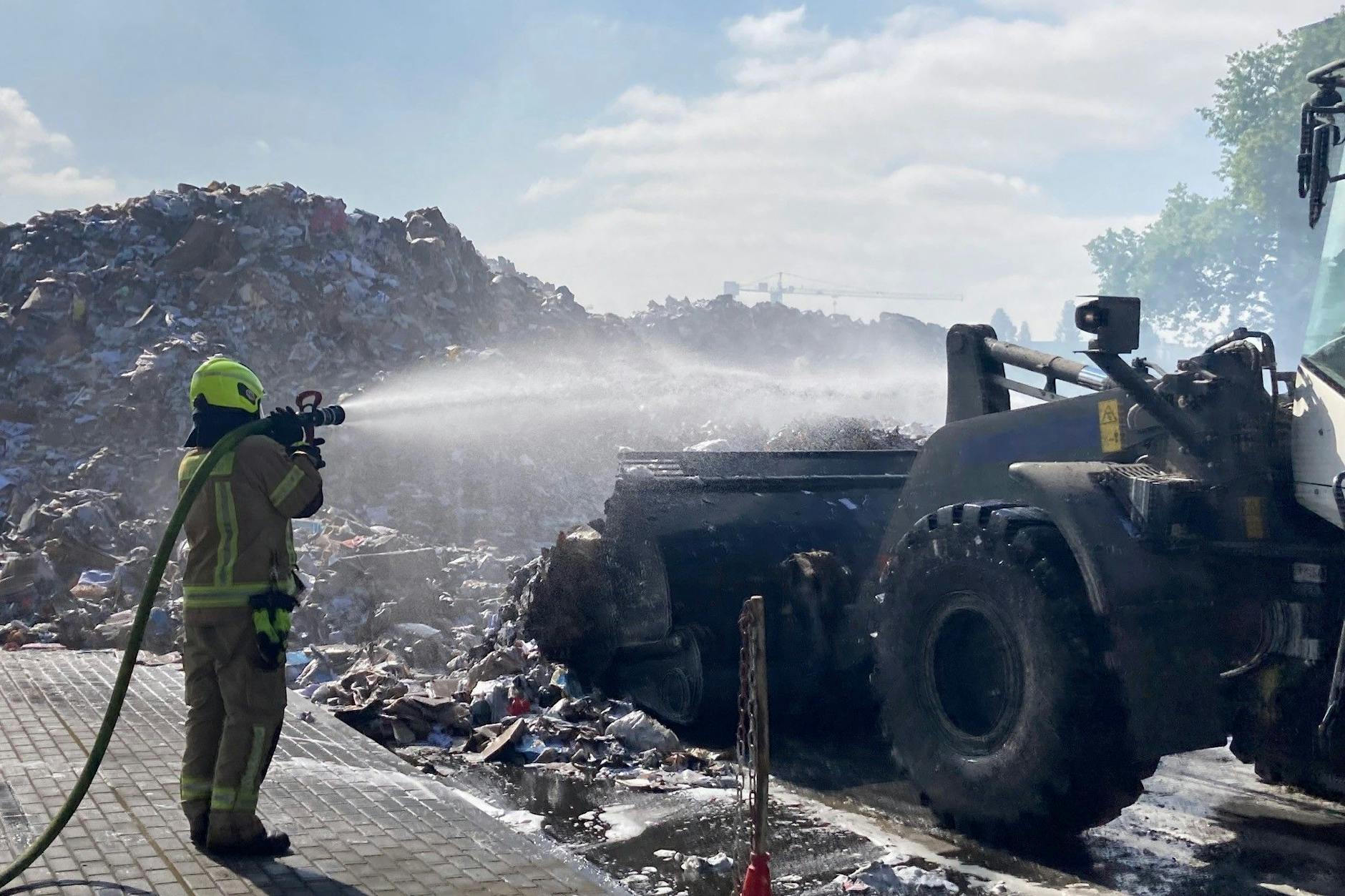 Auch am Donnerstag waren Feuerwehrleute damit beschäftigt, die glühenden Papierreste zu löschen, die per Radlader aus der Halle geholt wurden.