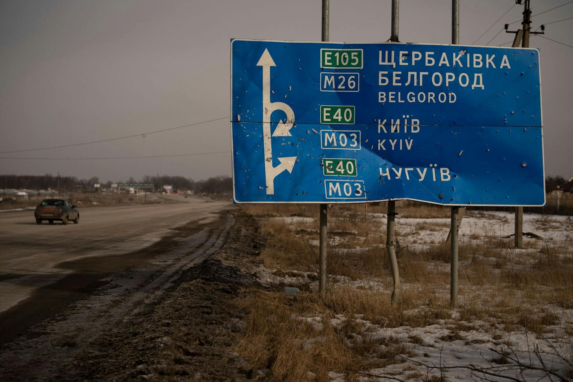ARCHIV - Ein von Kugeln und Granatsplittern beschädigtes Straßenschild auf der Straße zur russischen Stadt Belgorod.