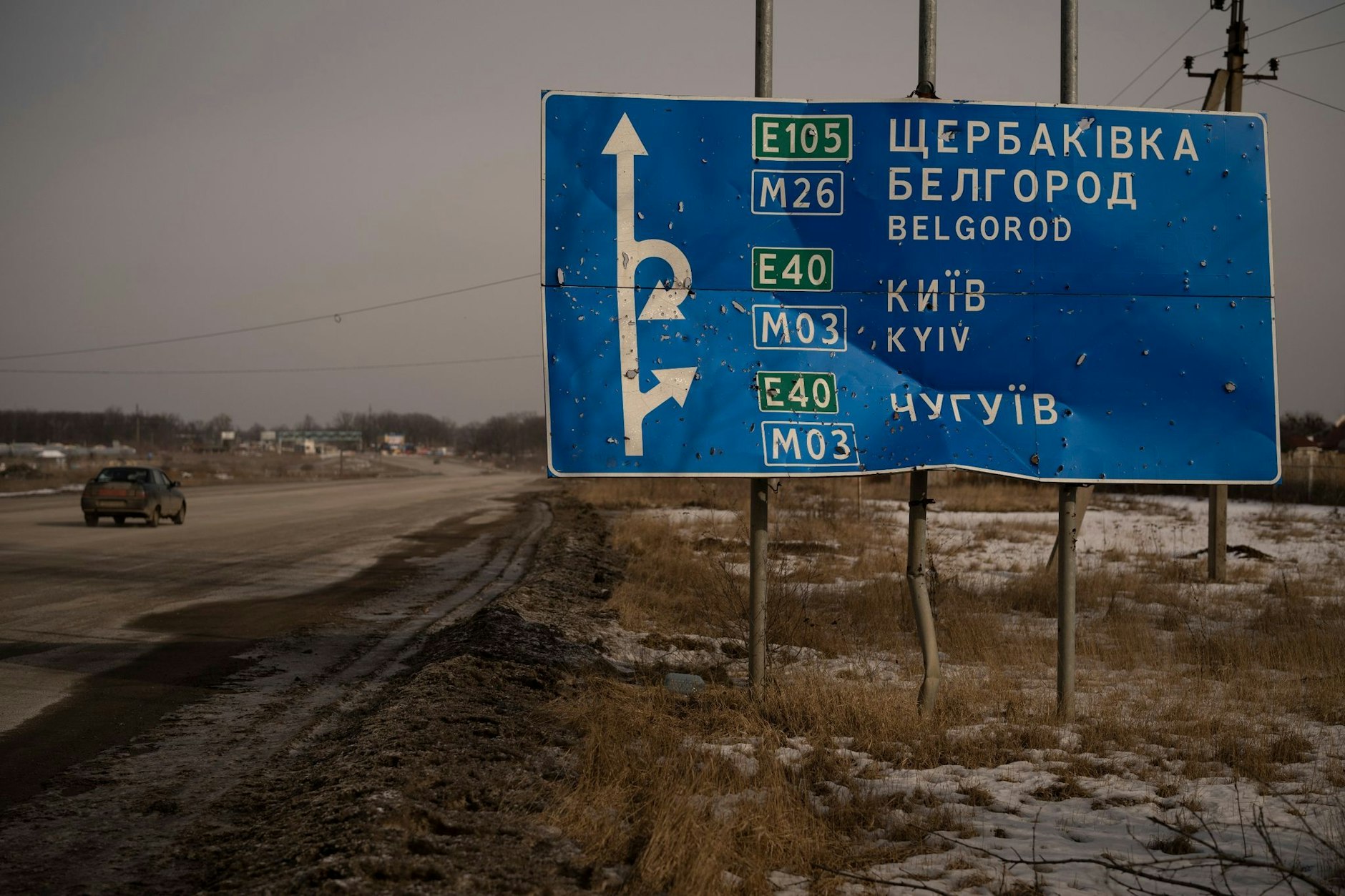 ARCHIV - Ein von Kugeln und Granatsplittern beschädigtes Straßenschild auf der Straße zur russischen Stadt Belgorod.