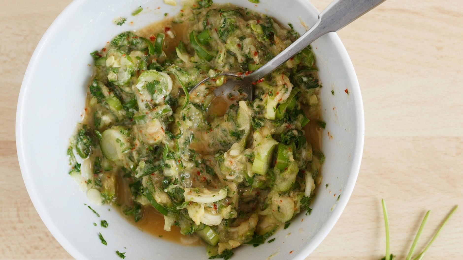 Die Zucchini-Puffer werden mit Eiern und Gewürzen angemischt.