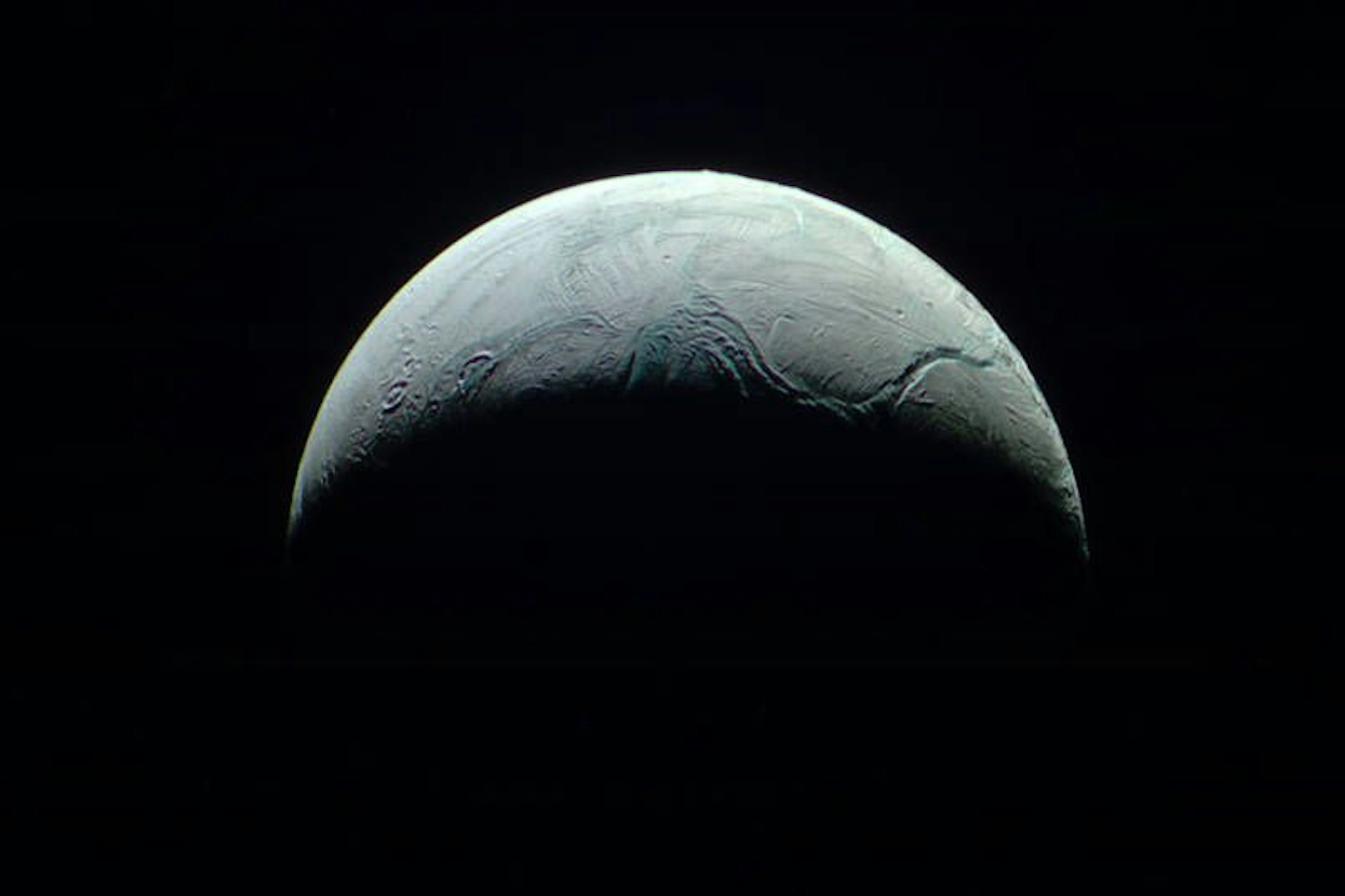 Der Saturn-Mond Enceladus ist von einer dicken, stellenweise brüchigen Eisdecke umhüllt.