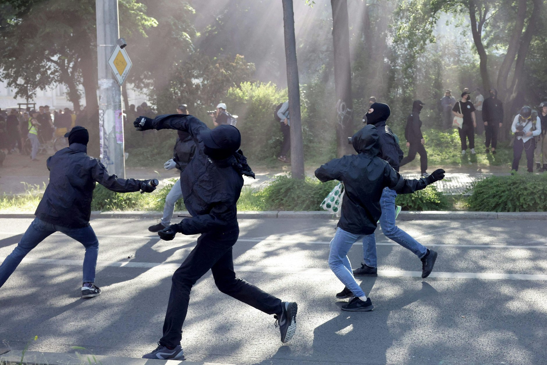 Linksextremisten werfen Flaschen und Pflastersteine in Richtung der Polizei. 