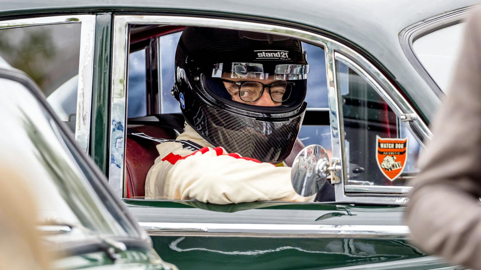 Schauspieler Rowan Atkinson bei einem Autorennen in einem alten Sportwagen.