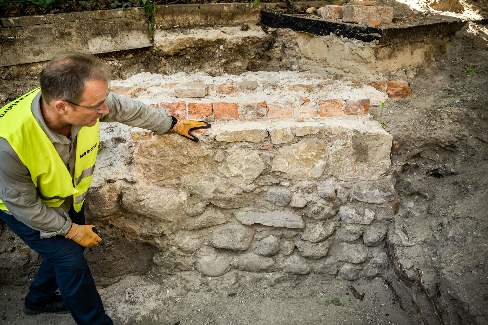 Der Archäologe Torsten Dressler zeigt den Aufbau der etwa 800 Jahre alten Fundamente der in Spandau ausgegrabenen Moritzkirche: Felstein, Kalkstein, Backstein.