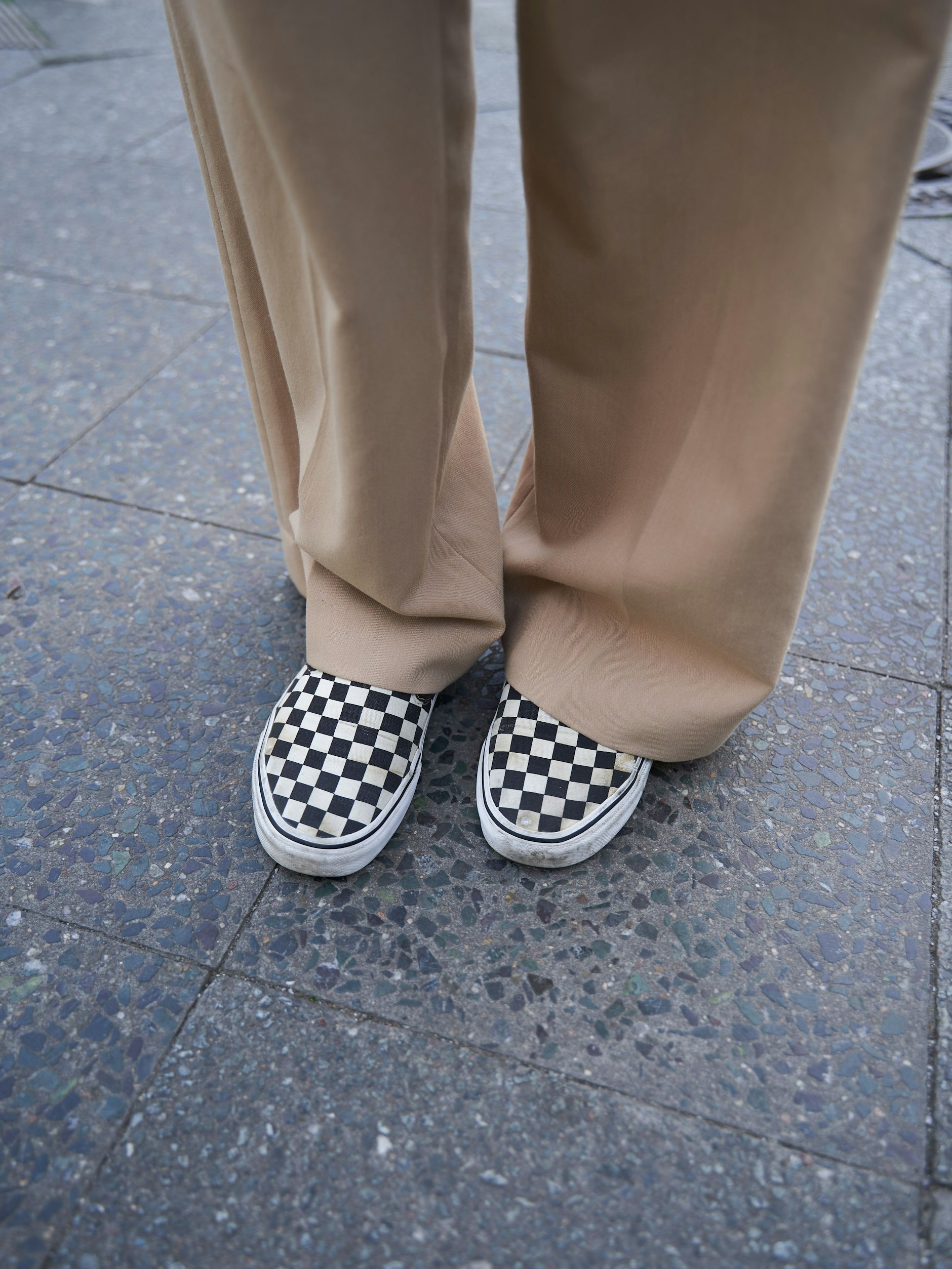 Klassische Checkerboard-Vans komplettieren den Look.
