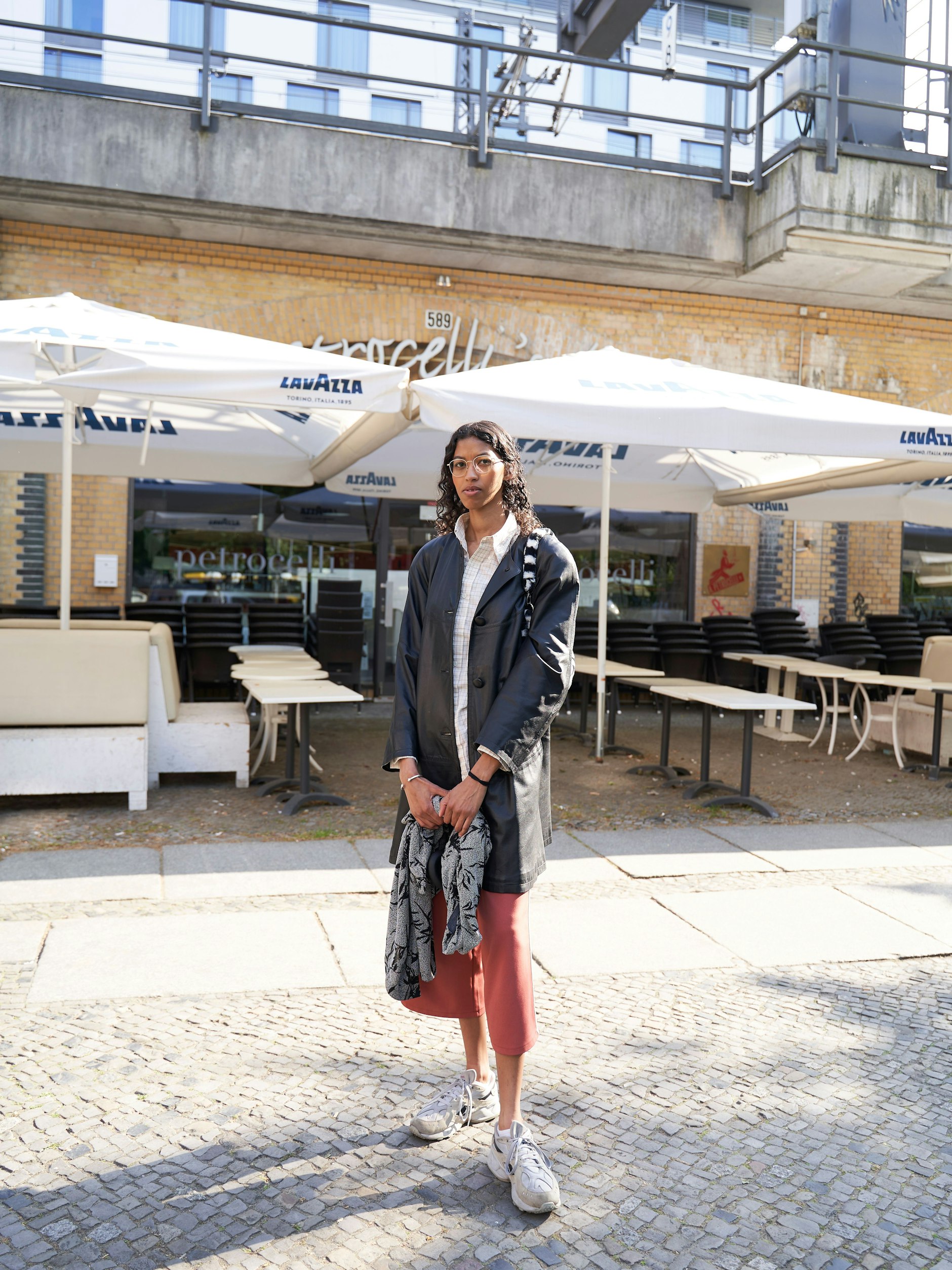 Mit schlanker Linie und gelocktem Wetlook spaziert Elke in Reebok-Sneakern durch die Sonne. Sie ist aus Mitte angereist, um „etwas zu trinken“. Wo? Natürlich im Schwarzen Café! Ihr Vintage-Outfit samt Plüschtasche hat sie in Berlin und Frankreich zusammengeshoppt.