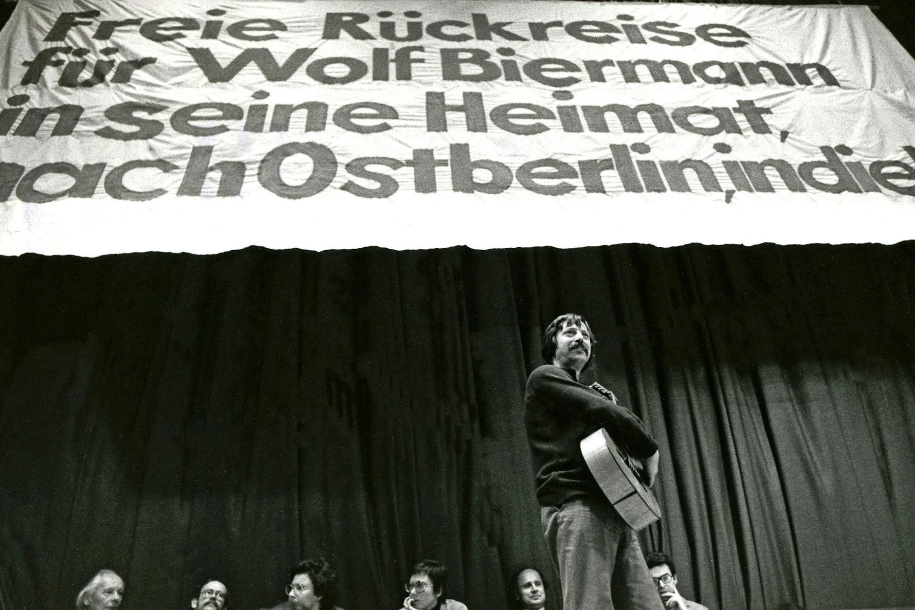 Solidaritätsveranstaltung mit Biermann am 19. November 1976 in Bochum. Auf dem Transparent steht die Forderung: „Freie Rückreise für Wolf Biermann in seine Heimat nach Ostberlin, in die DDR“. 