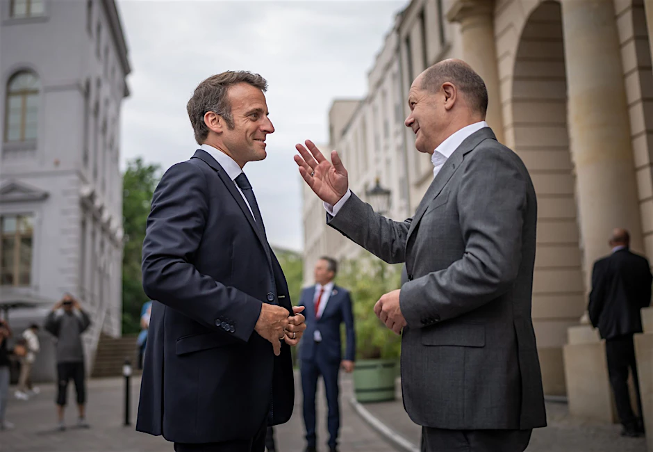 Bundeskanzler Olaf Scholz (SPD, r) begrüßt Emmanuel Macron, Präsident von Frankreich, vor einem gemeinsamen Abendessen zum Restaurant "Kochzimmer" in Potsdam.  