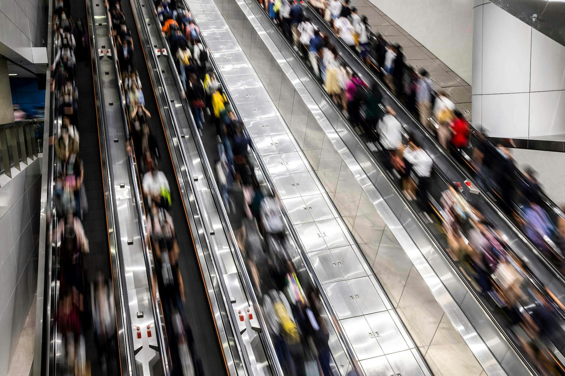 Menschen auf Rolltreppen auf einem Bahnhof in Hongkong