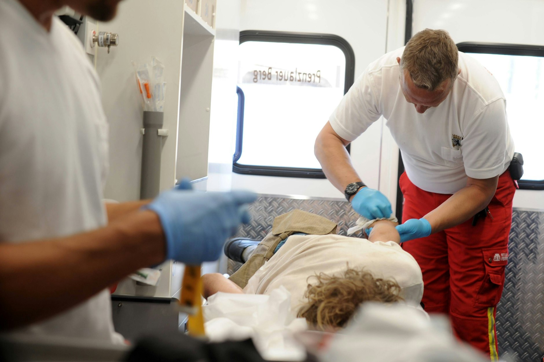 Sanitäter der Berliner Feuerwehr behandeln einen Patienten in einem Rettungswagen.