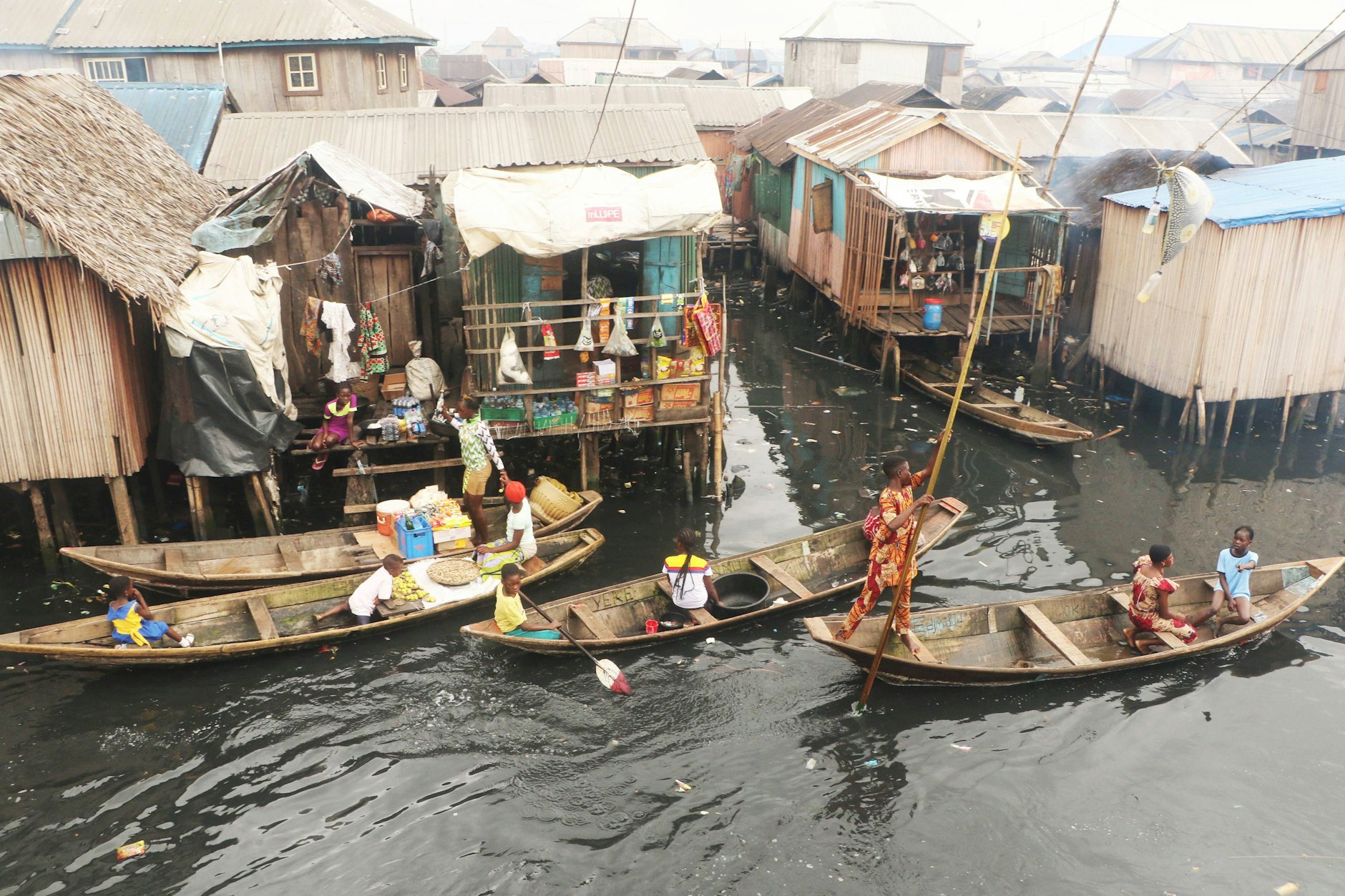 Anwohner und Kleinhändler in einem Kanu verkaufen Waren in der Fischergemeinde Makoko in der Lagune von Lagos.