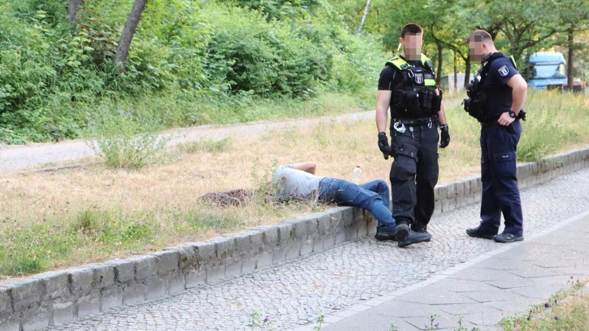 Einsatzkräfte der Polizei mit einem der Beteiligten.