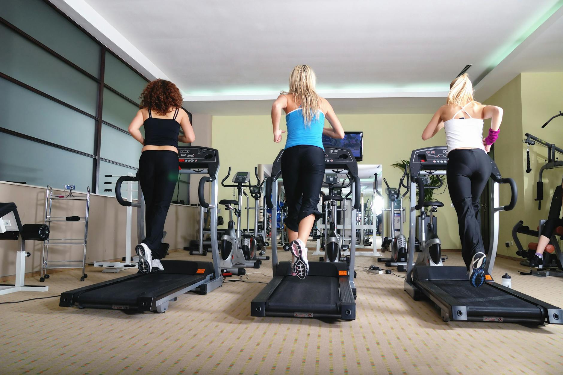 Frauen trainieren auf Laufbändern in einem Fitnessstudio: Sportunfälle können schmerzhaft enden.