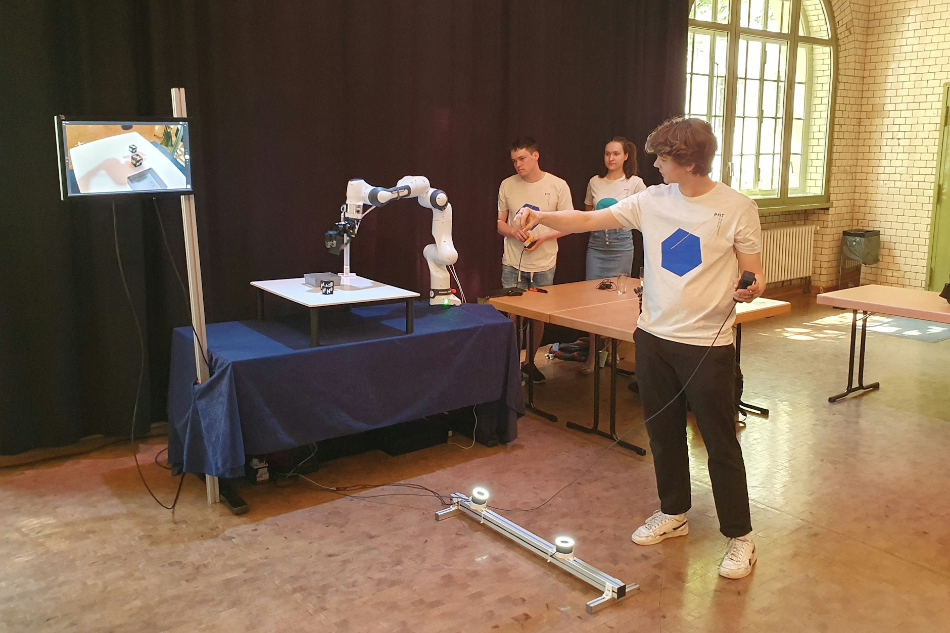 Studenten demonstrieren die Steuerung der von ihnen entwickelten Roboterhand.