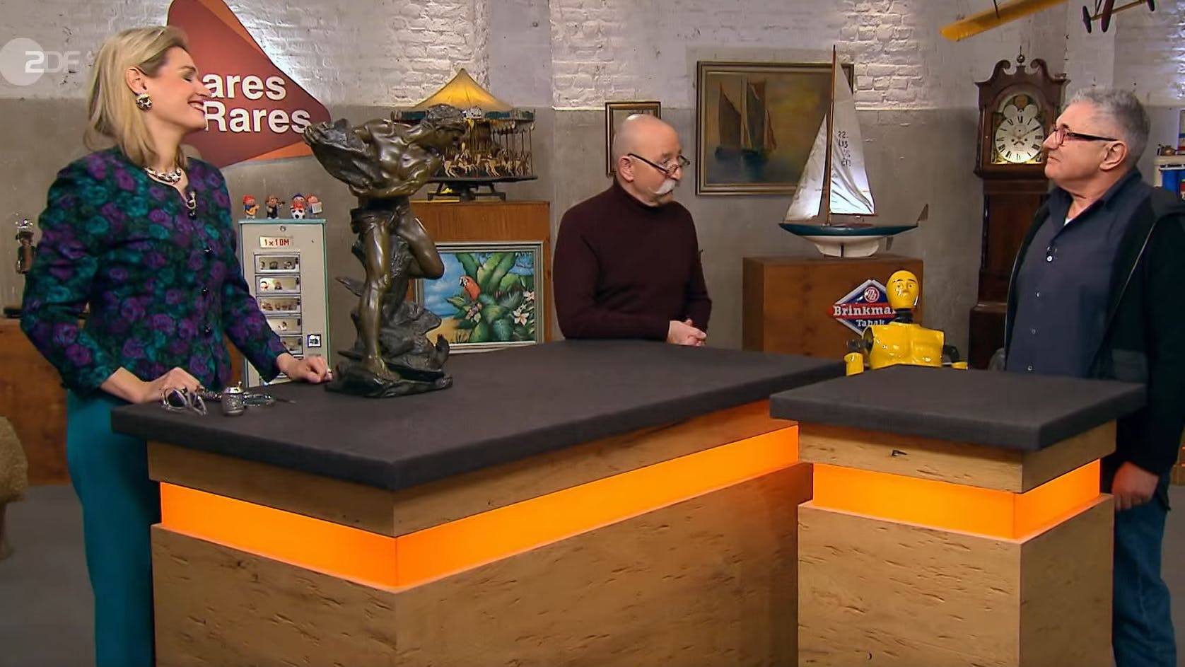 „Bares für Rares“-Expertin Dr. Bianca Berding kann den Wunschpreis von Verkäufer Gerhard (re.) leider nicht bestätigen. Kein Problem, die Händlerkarte gibt es von Horst Lichter trotzdem.