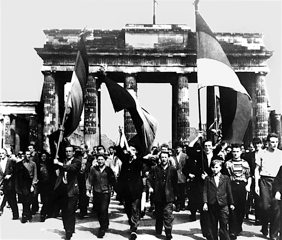 Ost-Berliner marschieren mit wehenden Fahnen vom Ost-Sektor aus durch das Brandenburger Tor. Am 17. Juni 1953 protestierten in der DDR eine Million Menschen gegen den noch jungen sozialistischen Staat – bis sowjetische Panzer den Aufstand beendeten. Dramatische Tage.