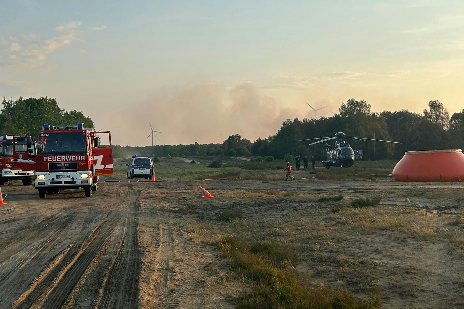 Die Feuerwehr kann den wieder aufgeflammten Waldbrand bei Jüterbog nur von den Schutzstreifen aus löschen
