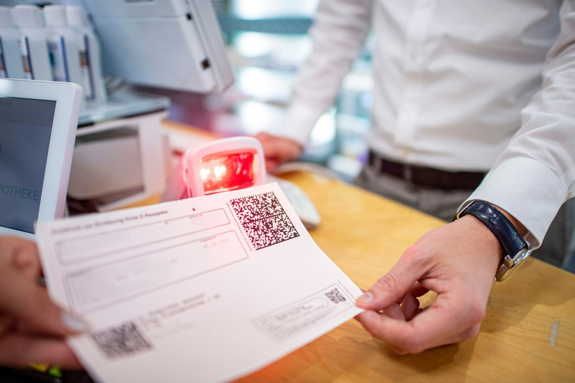 Ein Apotheker scannt den QR-Code eines E-Rezepts ein.