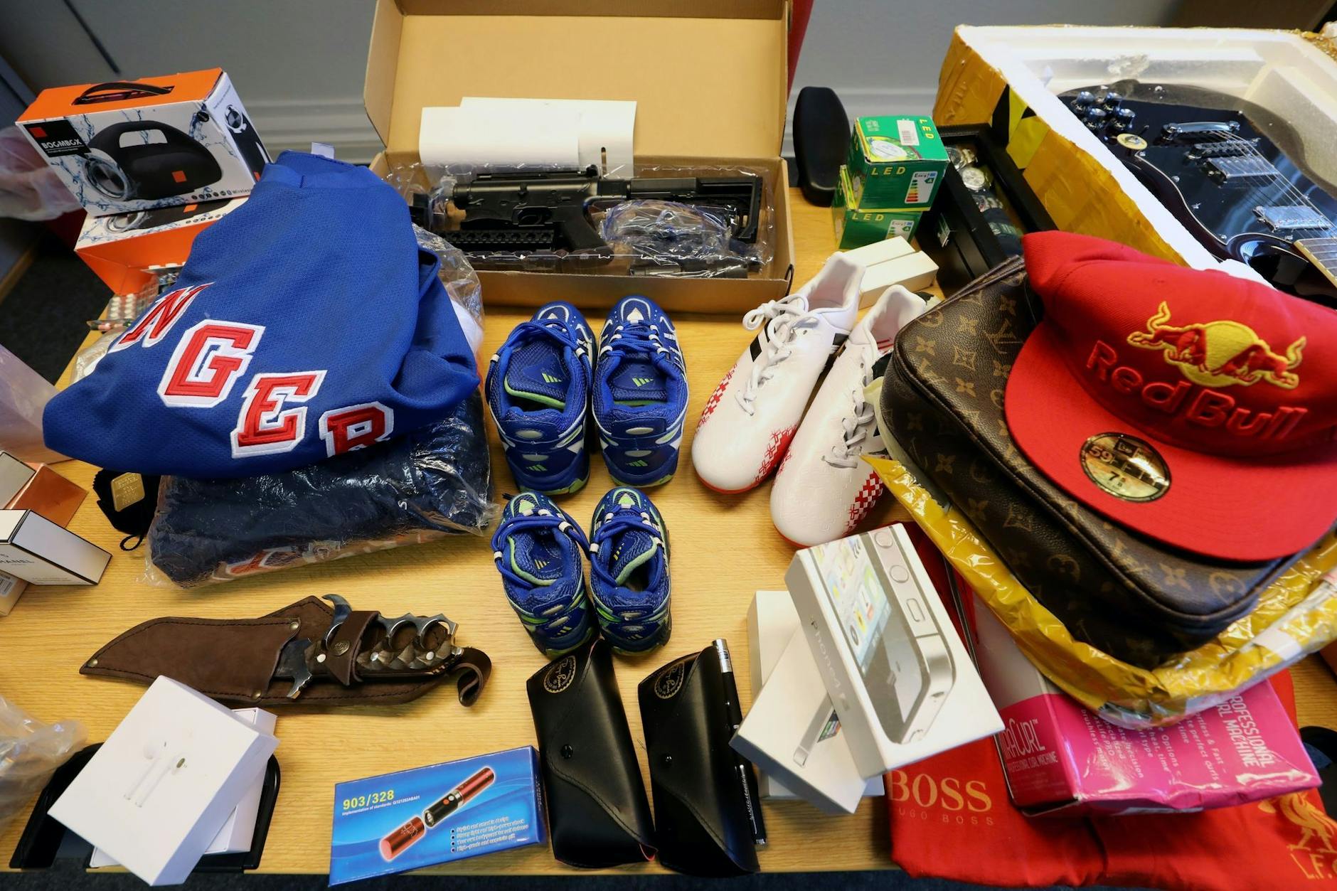 Eine Auswahl beschlagnahmter Waren, die der Zoll wegen Produktpiraterie aus dem Verkehr gezogen hatte - von Bekleidung über Smartphones bis hin zur Gitarre.