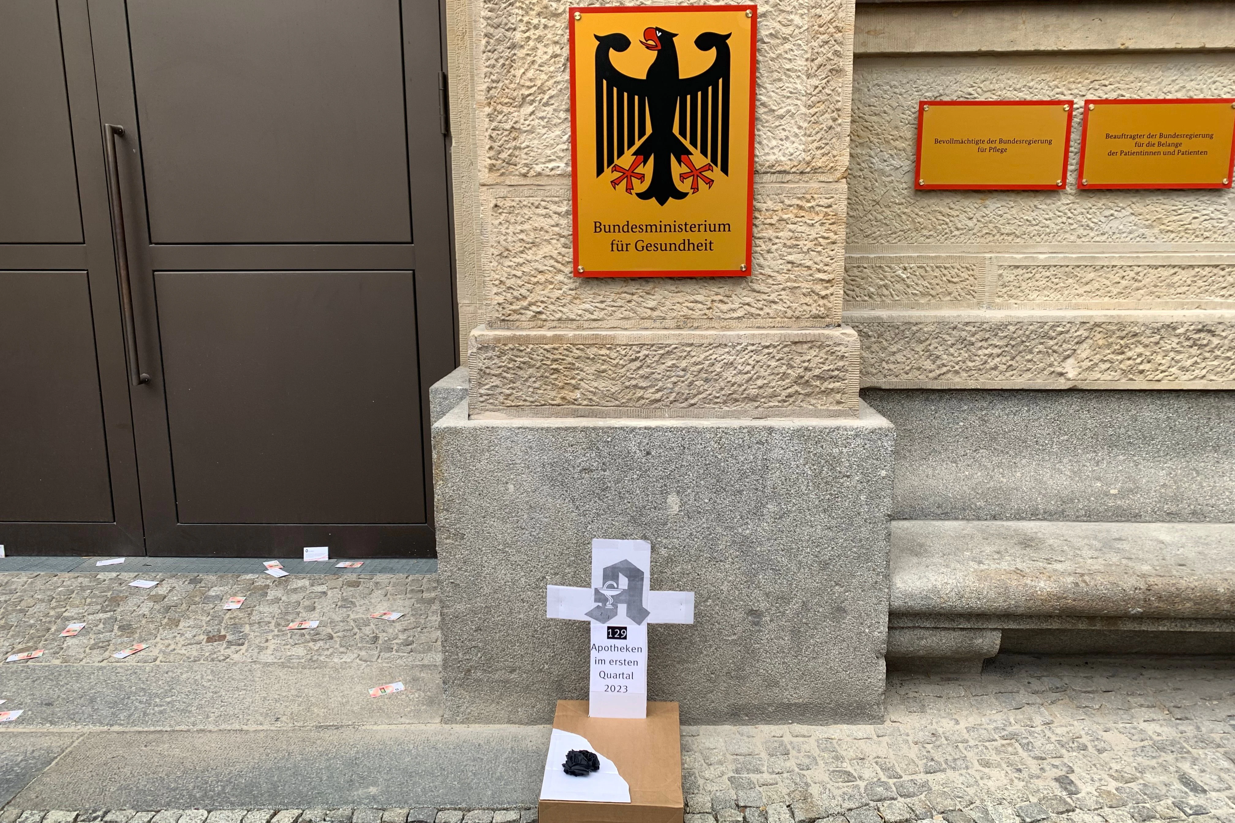 Ein Grabstein aus Pappkarton vor dem Bundesgesundheitsministerium erinnert an die 129 Apotheken, die im ersten Quartal 2023 geschlossen haben.