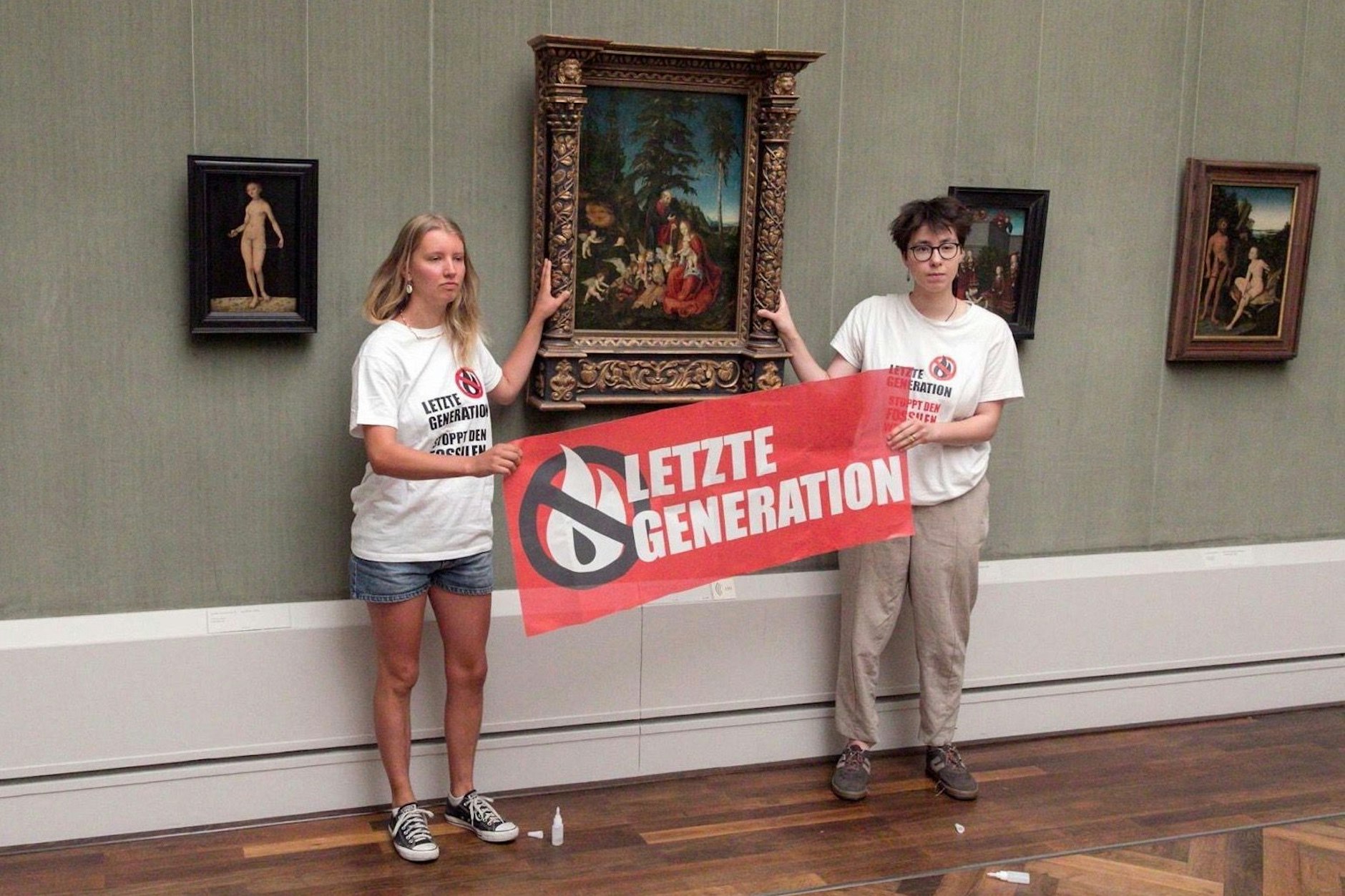 Lina E. klebte sich am Holzrahmen des Gemäldes „Ruhe auf der Flucht nach Ägypten“ fest.